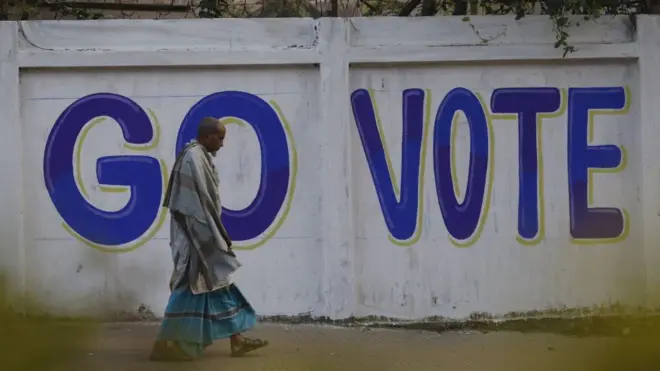 ২০২৪ সালের পাঁচই জানুয়ারি সাধারণ নির্বাচনের আগে একজন ব্যক্তি রাস্তায় হাঁটছেন