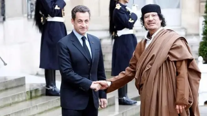 نیکولای سارکوزی در حال دست دادن با معمر قذافی