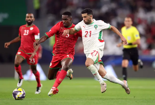 لاعبان من منتخبي عُمان والمغرب يتنافسان على الكرة خلال مباراة المجموعة الثانية في كأس العرب لكرة القدم في ملعب المدينة التعليمية في قطر