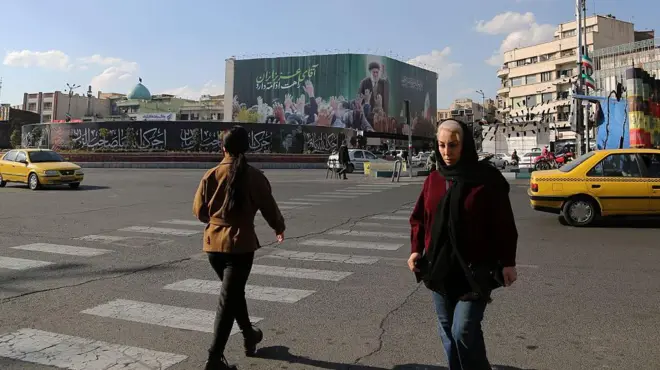 ساکنان در میدان انقلاب، یکی از شناخته‌شده‌ترین نقاط تهران، پس از حملاتی که ایالات متحده و اسرائیل در ۲۸ فوریه انجام دادند و موجب تلفات، از جمله کشته شدن آیت‌الله علی خامنه‌ای، و خسارت به شمار زیادی از ساختمان‌ها و خودروها شد، در تاریخ ۵ مارس ۲۰۲۶ به زندگی روزمره خود ادامه می‌دهند.