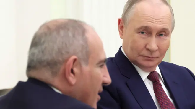 Путин смотрит на Пашиняна во время их встречи в Кремле.