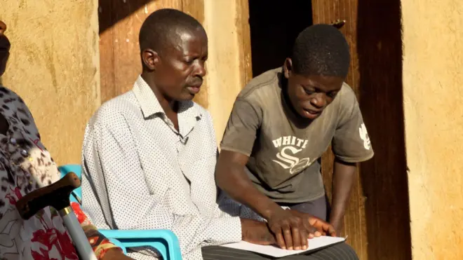 Un homme lisant le braille avec son fils à l'extérieur.