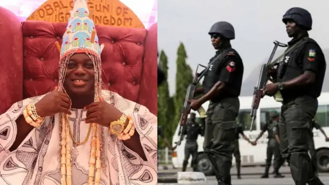 Awọn ọlọpaa meji duro wamawamu pẹlu ibọn lọwọ wọ, wọn wọ koto lori aṣọ dudu pẹlu ṣokoto kaaki