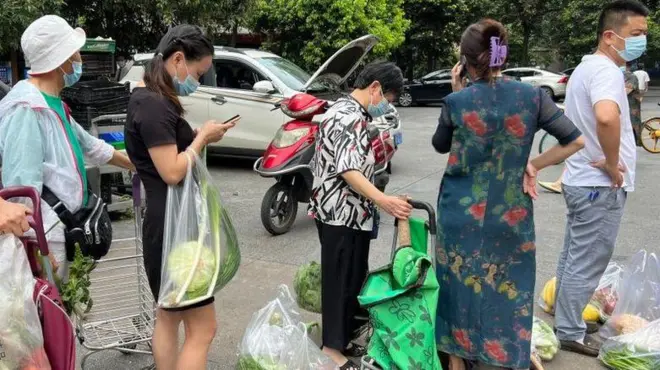 Çengdu kentinde kısıtlamalar başlamadan önce sebze almak için sıraya giren insanlar