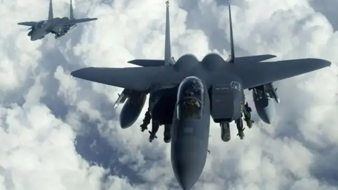 Два истребителя F-15 в небе над облаками