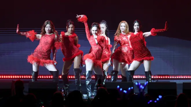 캣츠아이가 붉은 의상을 입고 무대 위에서 공연하고 있다