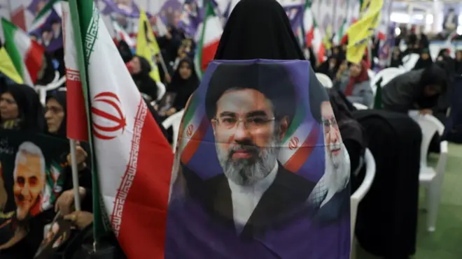سيدة إيرانية تضع صورة كبيرة للمرشد الجديد مجتبى خامنئي على ظهرها أثناء ا مراسم تأبين لضحايا الحرب الإيرانية الأمريكية الإسرائيلية في مسجد مصلى بطهران، إيران،