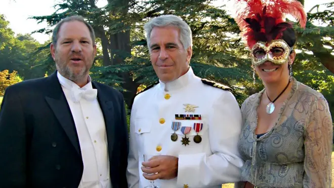 Harvey Weinstein, Jeffrey Epstein and Ghislaine Maxwell are pictured standing on the lawn at Royal Lodge on the royal estate in Windsor with trees in the background. All wear fancy dress with Weinstein and Epstein wearing suits and Maxwell is seen wearing a mask.