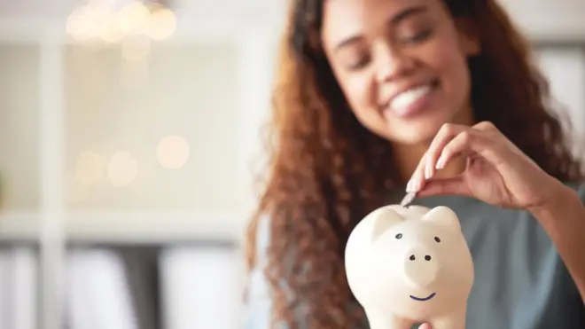 Pesin wey dey put money for piggy bank