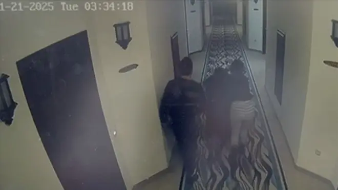 Güvenlik kamerası görüntülerinde bir erkek ve kadın, çocuklarıyla koridorda koşuyor