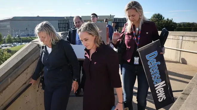 Kadın gazeteciler ellerine eşyalarıyla sıra halinde Pentagon'dan çıkıyor