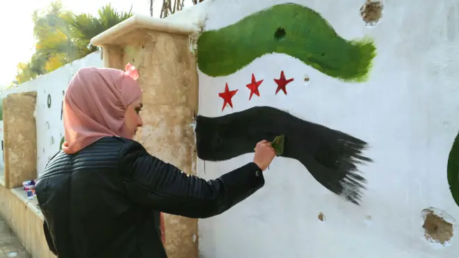 Женщина в Дейр-эз-Зоре рисует граффити на стене 