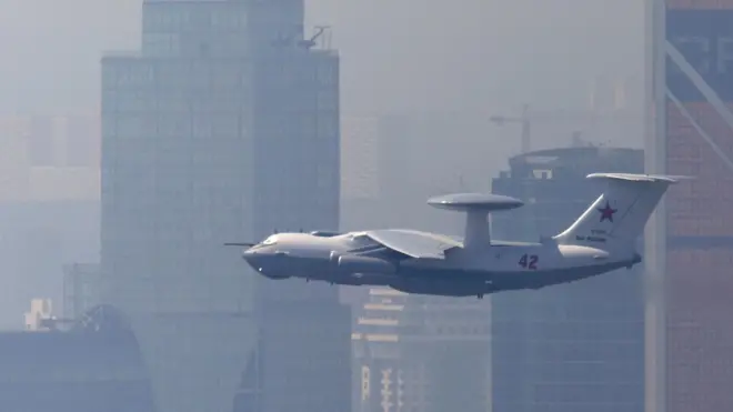 Самолет-радар А-50 в воздухе на фоне высотных домов