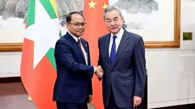 တရုတ် - မြန်မာ နှစ်နိုင်ငံ အလံကို နောက်ခံထားပြီး နေပြည်တော် နိုင်ငံခြားရေးဝန်ကြီး ဦးတင်မောင်ဆွေ က ဘယ်ဘက်ခြမ်းမှာရပ်ကာ တရုတ်နိုင်ငံခြားရေးဝန်ကြီး ဝမ်ယိ က ညာဘက်ခြမ်းမှာ ရပ်ပြီး လက်ဆွဲနှုတ်ဆက်နေကြပါတယ်