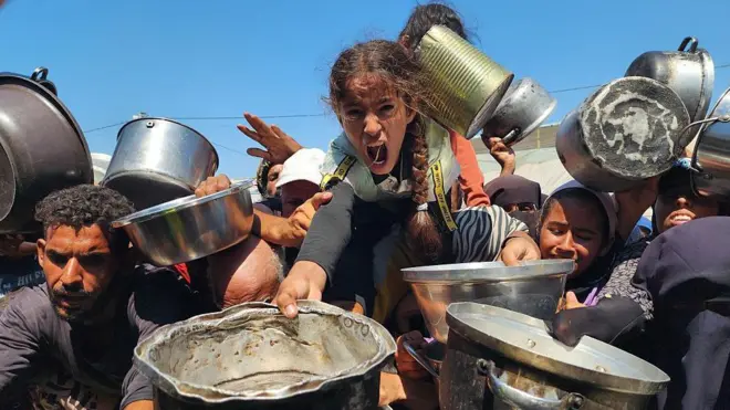 Hombres, mujeres y niños buscan comida en Gaza. 