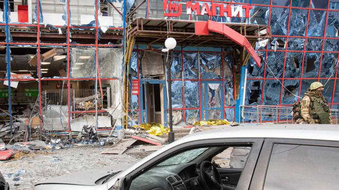 Автомобиль у здания торгового центра, поврежденного в результате обстрела Белгорода, на улице Плеханова