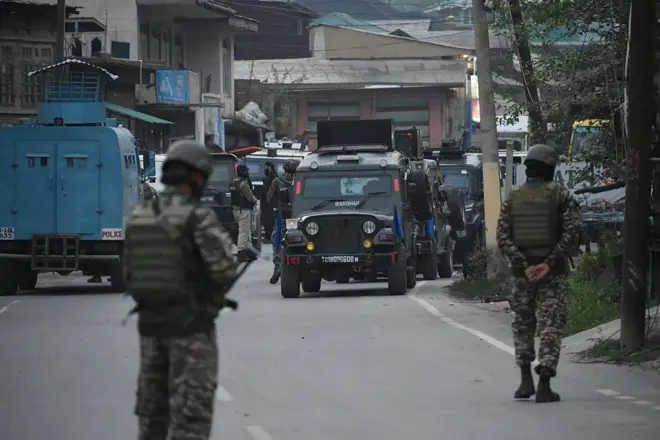 Security forces patrol the street near Wuyan area of Pampore in south Kashmir