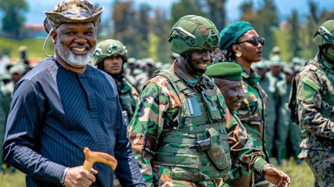 Corneille Nangaa wambaye ingofero ya gisirikare n'ishati y'ubururu bwijimye, Sultani Makenga wambaye ingofero n'imyenda ya gisirikare na Bernard Byamungu iruhande rwe