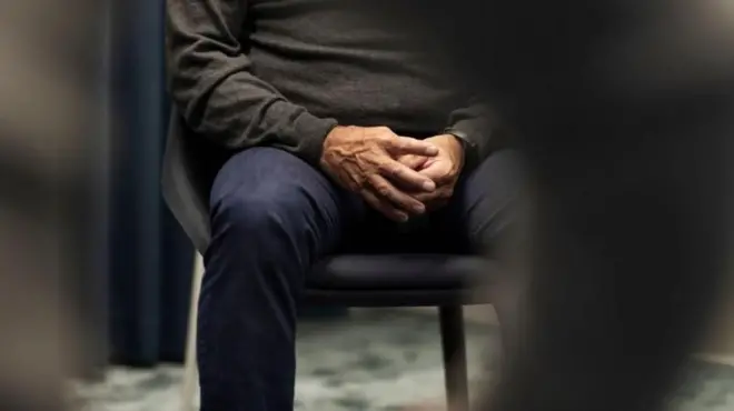 Un homme assis sur une chaise