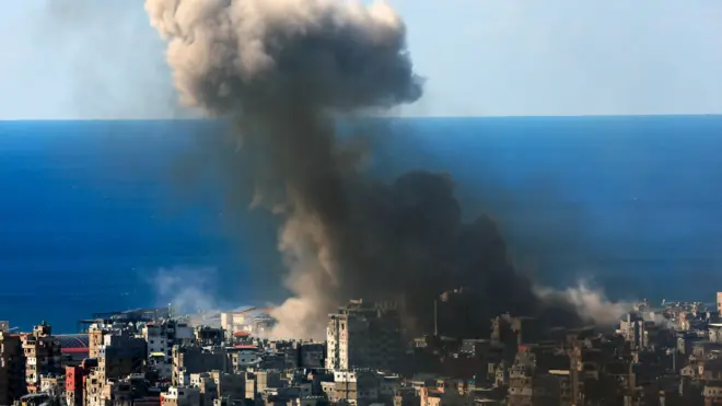 Coluna de fumaça subindo de cidade