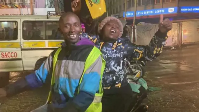 Umugore wazamuye intoki ahetswe kuri moto, mu kwishimira intsinzi ya Ruto