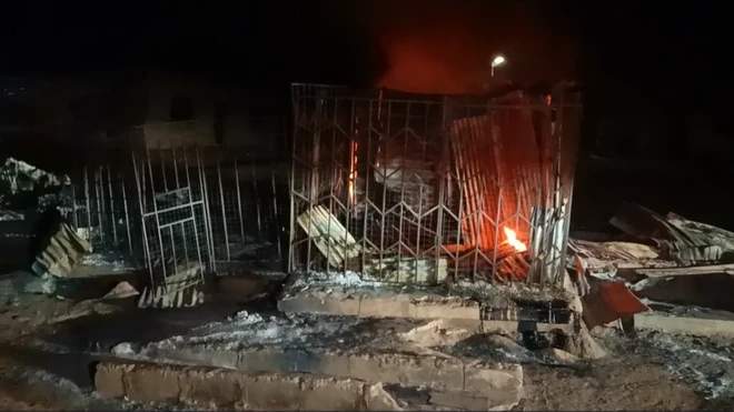 Foto of store wey still dey on fire hours afta di attack for Kaiama local govment area of Kwara state