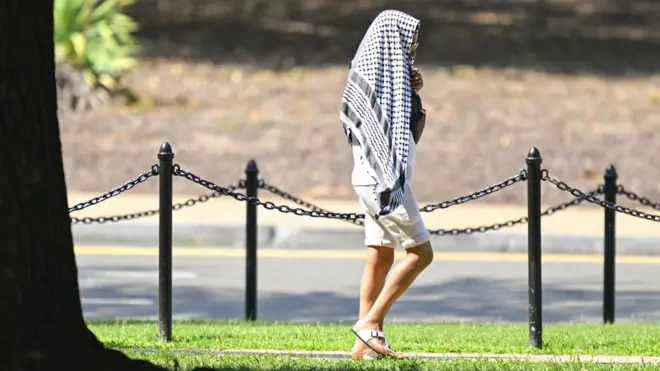 person covering head with checked clothe in sun