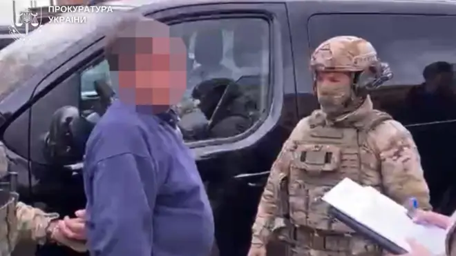 Чоловік із заблюреним обличчям, біля нього чоловік у військові формі