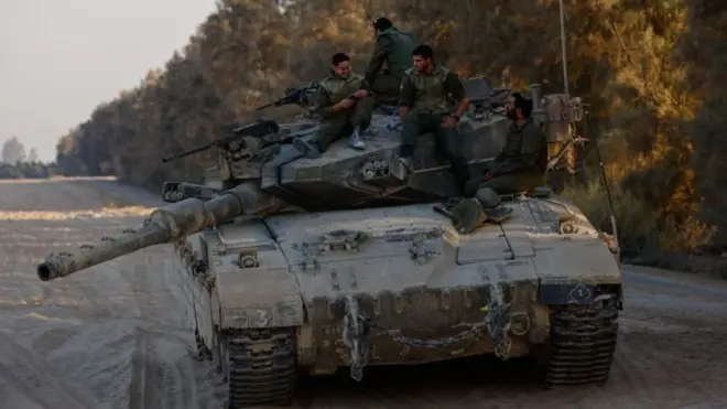 جنود إسرائيليون على ظهر دبابة قرب الحدود مع غزة، يبلغ عددهم أربعة