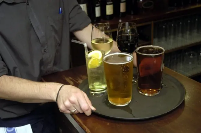 Pessoa levando bandeja de bebidas