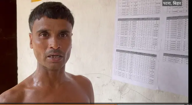 सूचि में नाम ढूंढते हुए शख्स