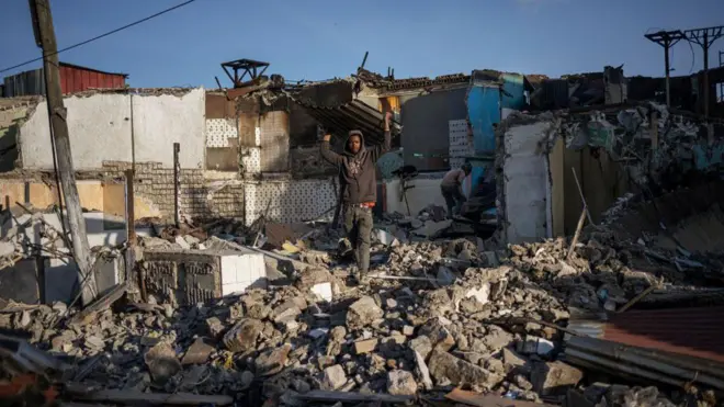 ከቤቶች ከፈረሱበት ስፍራ ቆርቆሮ ተሸክሞ የሚወጣ ወጣት