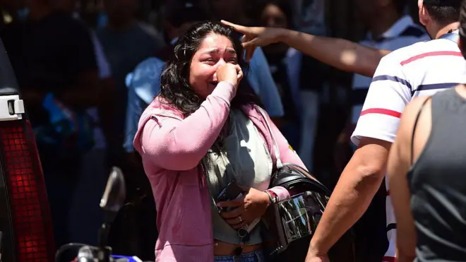 Mujer llora en medio del resctae de una víctima de terremoto en Colombia