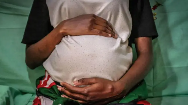 Girl hold her baby bump