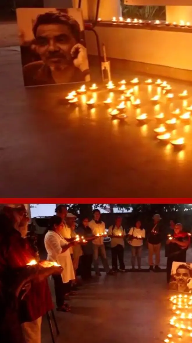 පුද්ගලයෙකුගේ ෆොටෝ එකක් ඉදිරිපිට පහන් දල්වා ඇත.