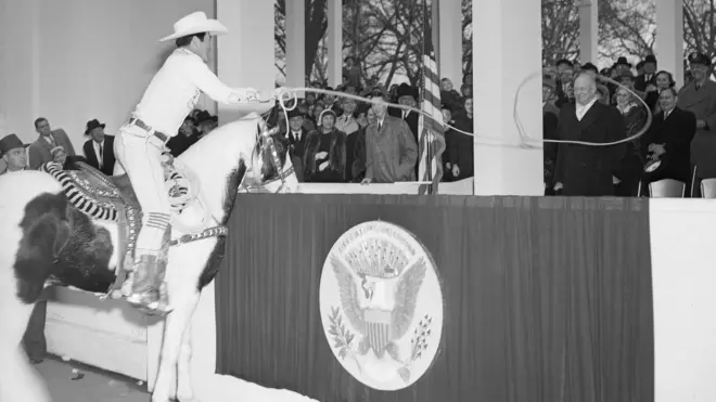 راعي البقر والنجم السينمائي مونتي مونتانا يطوق الرئيس دوايت أيزنهاور خلال حفل تنصيبه في 1957