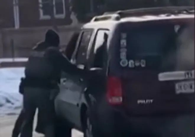 Dois policiais próximos de um carro