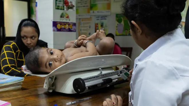A nurse weighs a six-month-old baby at the weekly medical and nutrition clinic run by the Colombo Public Health Department on September 12, 2023 in Colombo, Sri Lanka