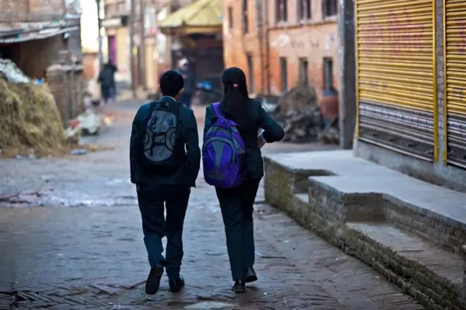 एउटा गल्लीमा हिँडिरहेका दुई जना विद्यार्थीहरूको तस्बिर। फाइल फोटो