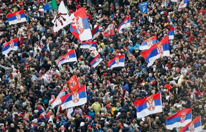 Sırbistan bayrakları taşıyan protestocular 15 Mart 2025 tarihinde Belgrad'a yürürken.