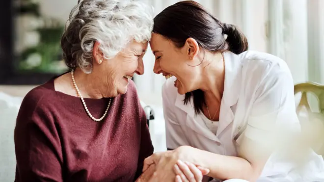 Idosa ri ao lado de mulher mais jovem