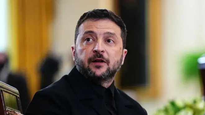 Ukrainian President Volodymr Zelensky, wearing a black suit, attends a meeting in Washington. 