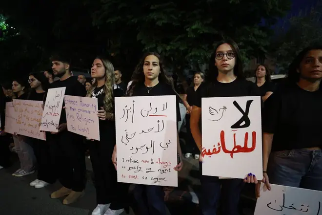 تجمع العشرات حاملين أعلاماً ولافتات تحمل رسائل دعم لأهالي السويداء، في مجدل شمس للمطالبة بإنهاء الاشتباكات بين العرب البدو وبعض الجماعات المسلحة الدرزية في مدينة السويداء في 19 يوليو/تموز 2025