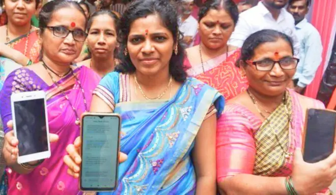 महिलाएं अपने फ़ोन को दिखाते हुए