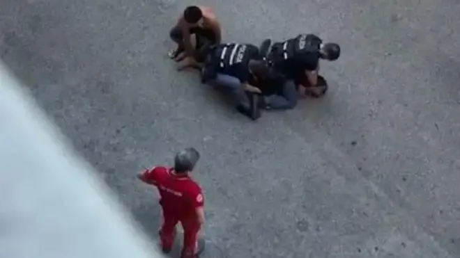  لقطة شاشة من فيديو متداول على وسائل التواصل الاجتماعي، يظهر م عبد الرحيم فقير، وهو مُقيد من قبل شرطيين ورجل ثالث فوأحد المسعفين ينظر إليه بينما كان يلفظ أنفاسه الأخيرة