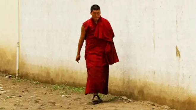 Monje tibetano caminando por una calle