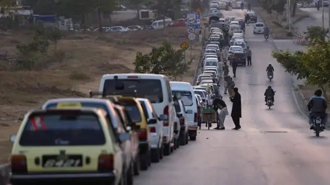 له پرلپسې ګرانۍ سره ځای ځای د ګاډو اوږده قطارونه پمپونو ته په قطار ولاړ دي.
