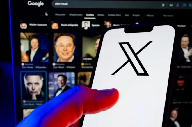 Bir cep telefonunda X logosu ve arka planda şirketin sahibi Elon Musk. 