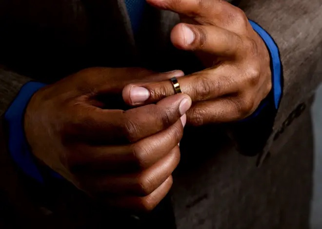 Un homme portant sa bague de mariage.