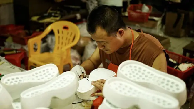 رجل صيني يعمل على صناعة نعل الأحذية